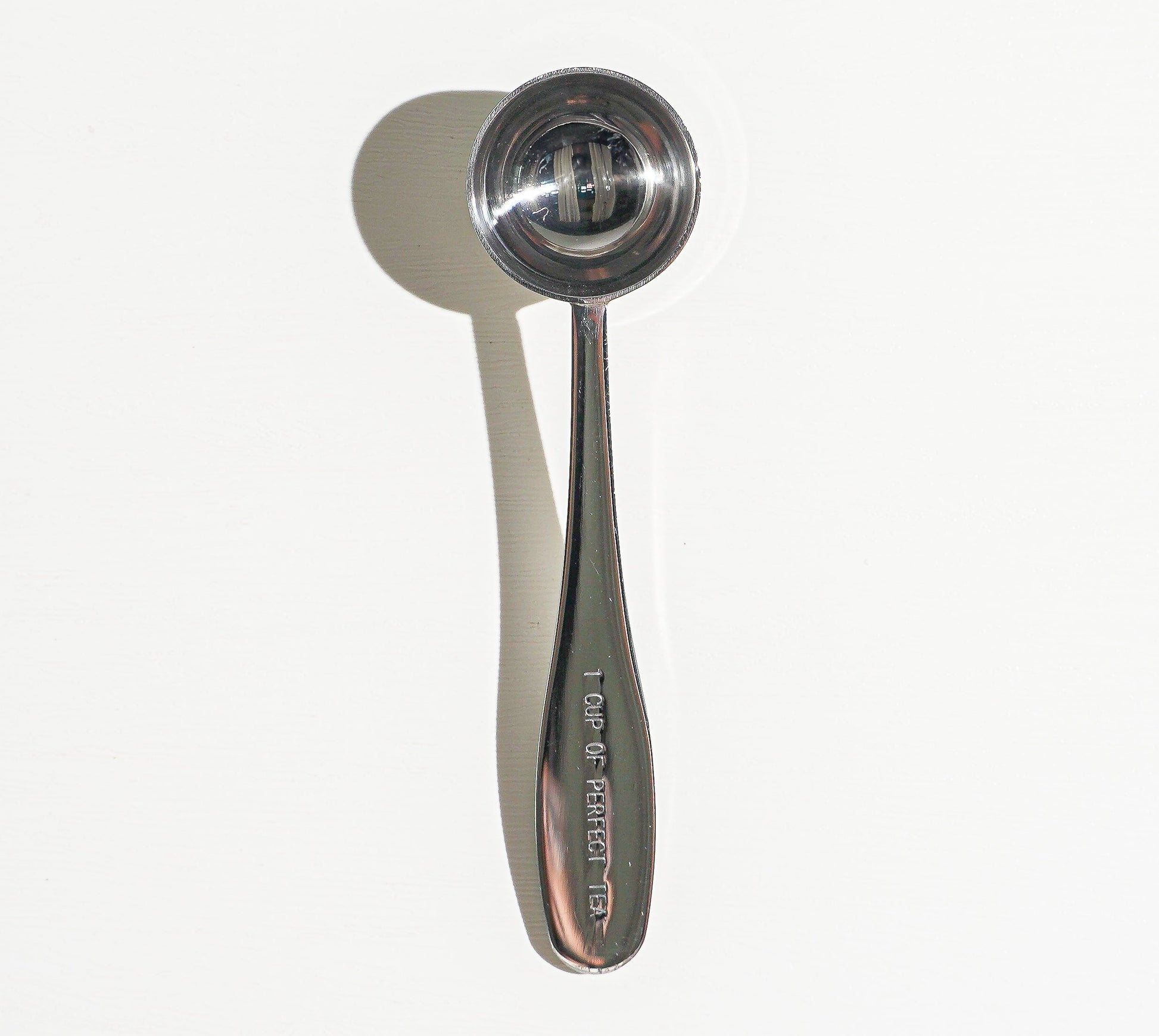 Metallic measuring spoon on a white background